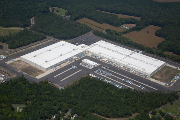Aerial view of warehouse, loading docks, parking, and greenery.