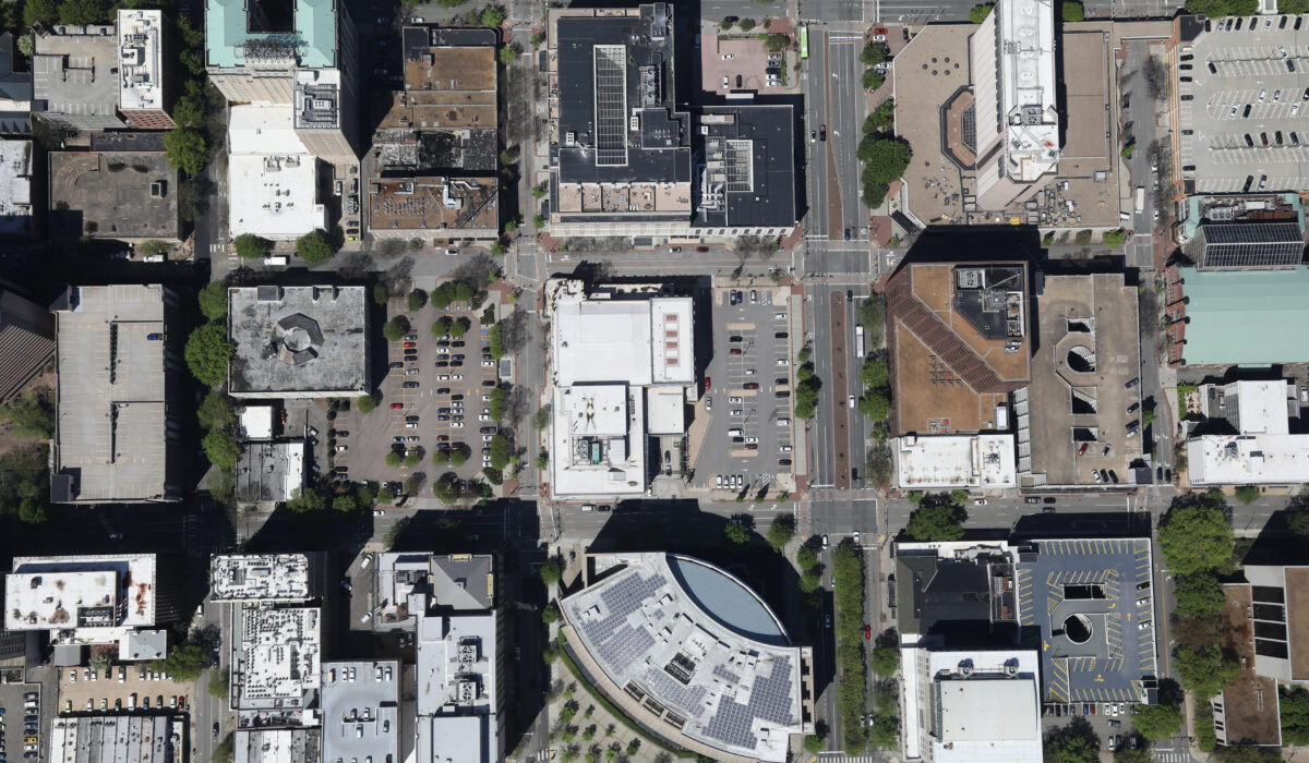 Aerial view of urban block with streets, buildings, and trees.
