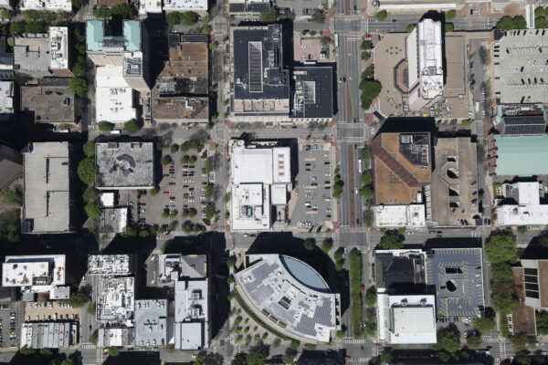 Aerial view of urban block with streets, buildings, and trees.