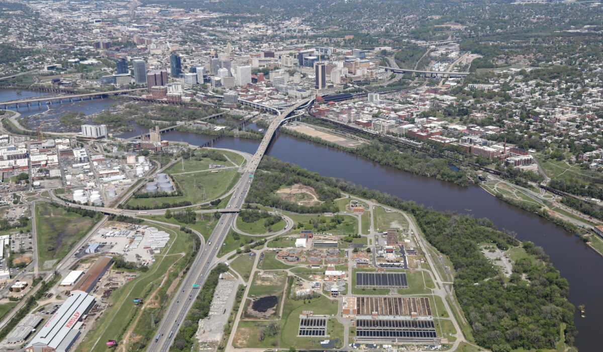 Aerial cityscape: highways, river, bridges, buildings, industry, greenery.