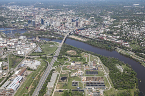 Aerial cityscape: highways, river, bridges, buildings, industry, greenery.