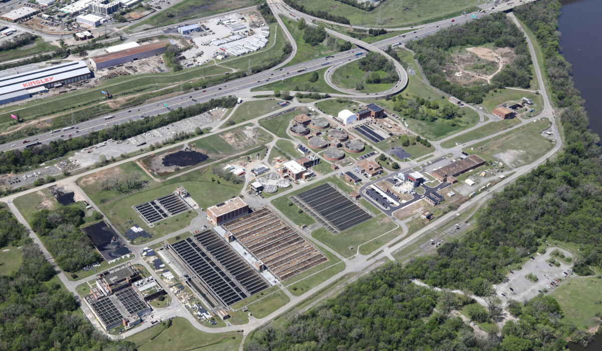 Aerial view of large water treatment plant amid greenery.