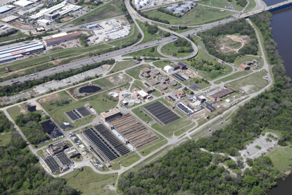 Aerial view of large water treatment plant amid greenery.