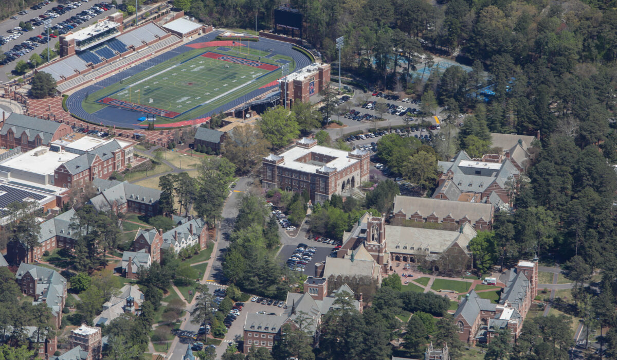 Aerial view: campus, stadium, buildings, walkways, and green spaces.