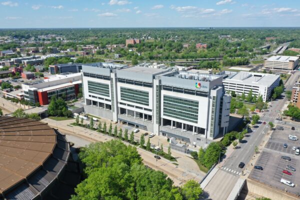 Aerial view of a modern hospital, parking lots, and city.