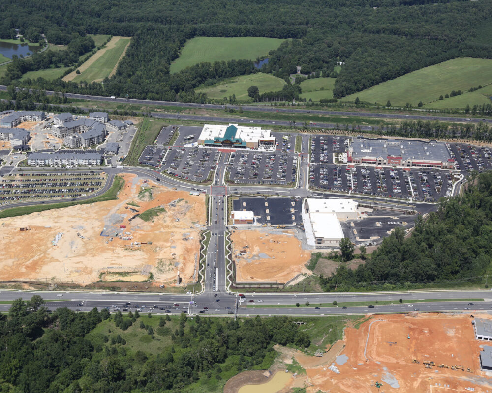 Aerial view of modern office park, greenery, and parking lots.