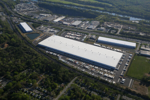 Aerial view of large warehouse complex with docks and surroundings.