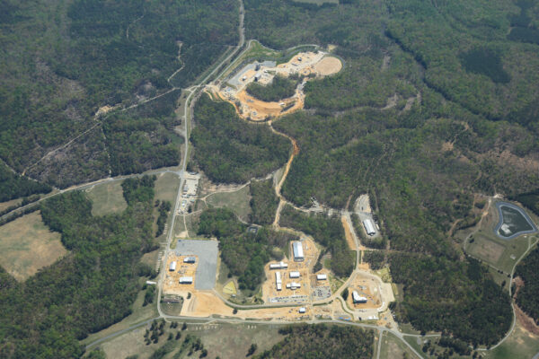 Aerial view: training facility amid forest, with roads and buildings.