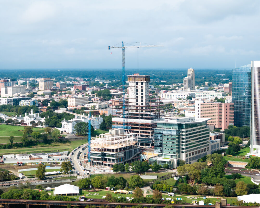 Aerial view of city, crane atop high-rise under construction.