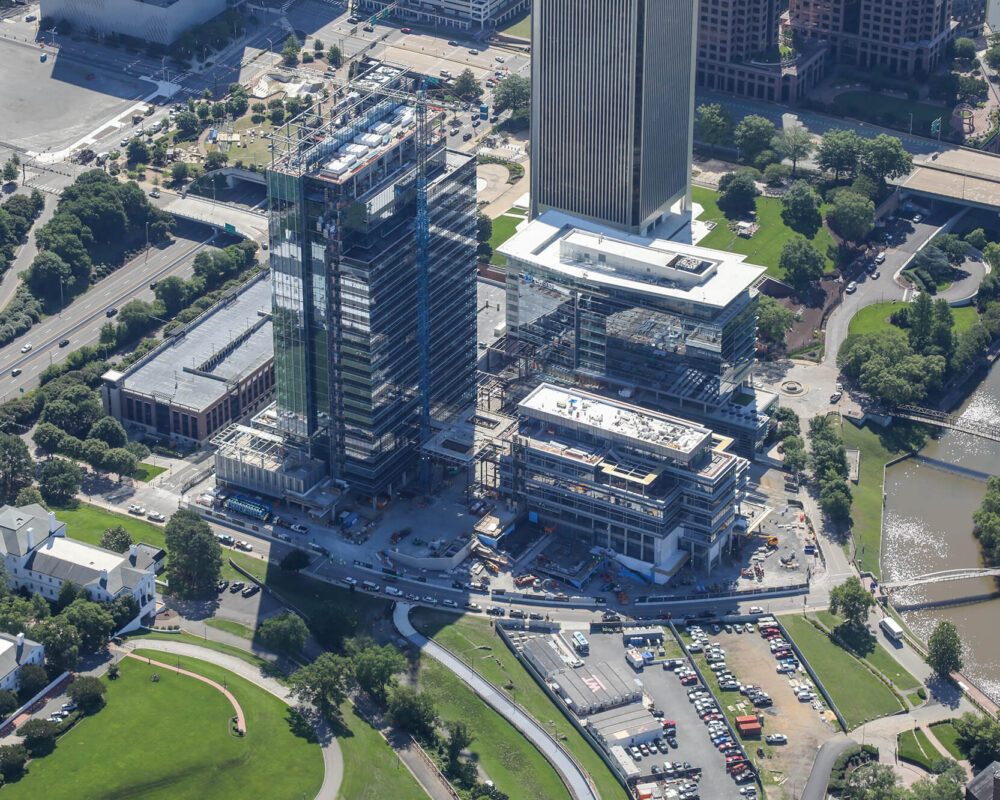 Aerial view of city construction site with cranes and vehicles.